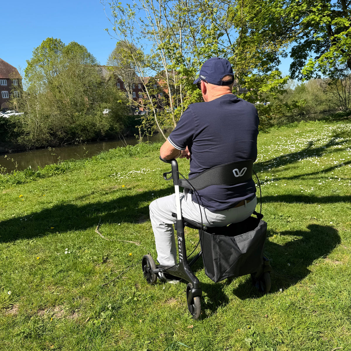 A four-wheeled rollator with a padded seat and brakes, in an Easy Living Mobility store