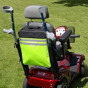 A high-visibility green walking stick bag attached to the back of a red mobility scooter, featuring a gray seat and black handle grips.